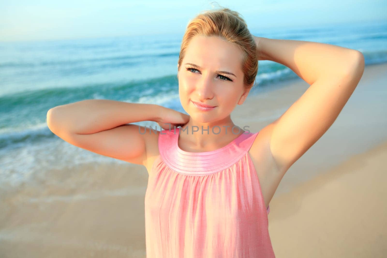 Portrait of the beautiful woman on the beach at sunrise time