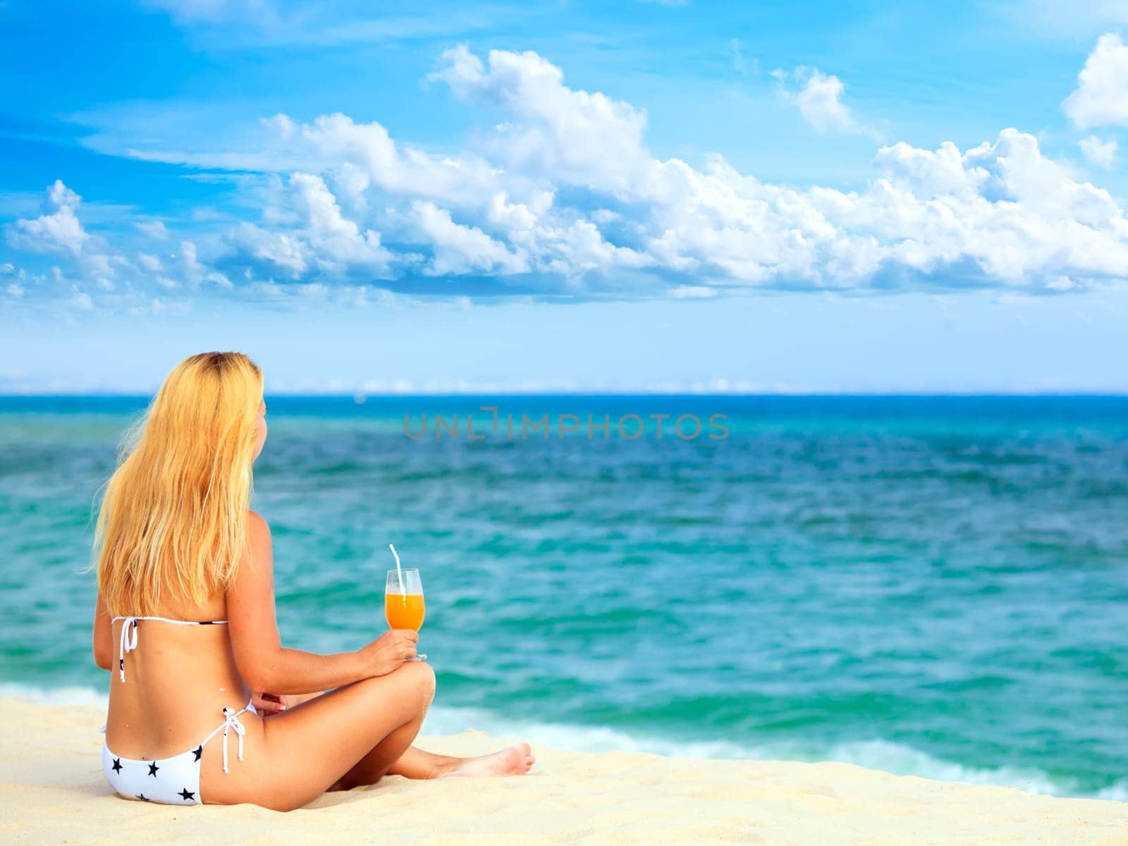 Wiman with juice on the tropical beach