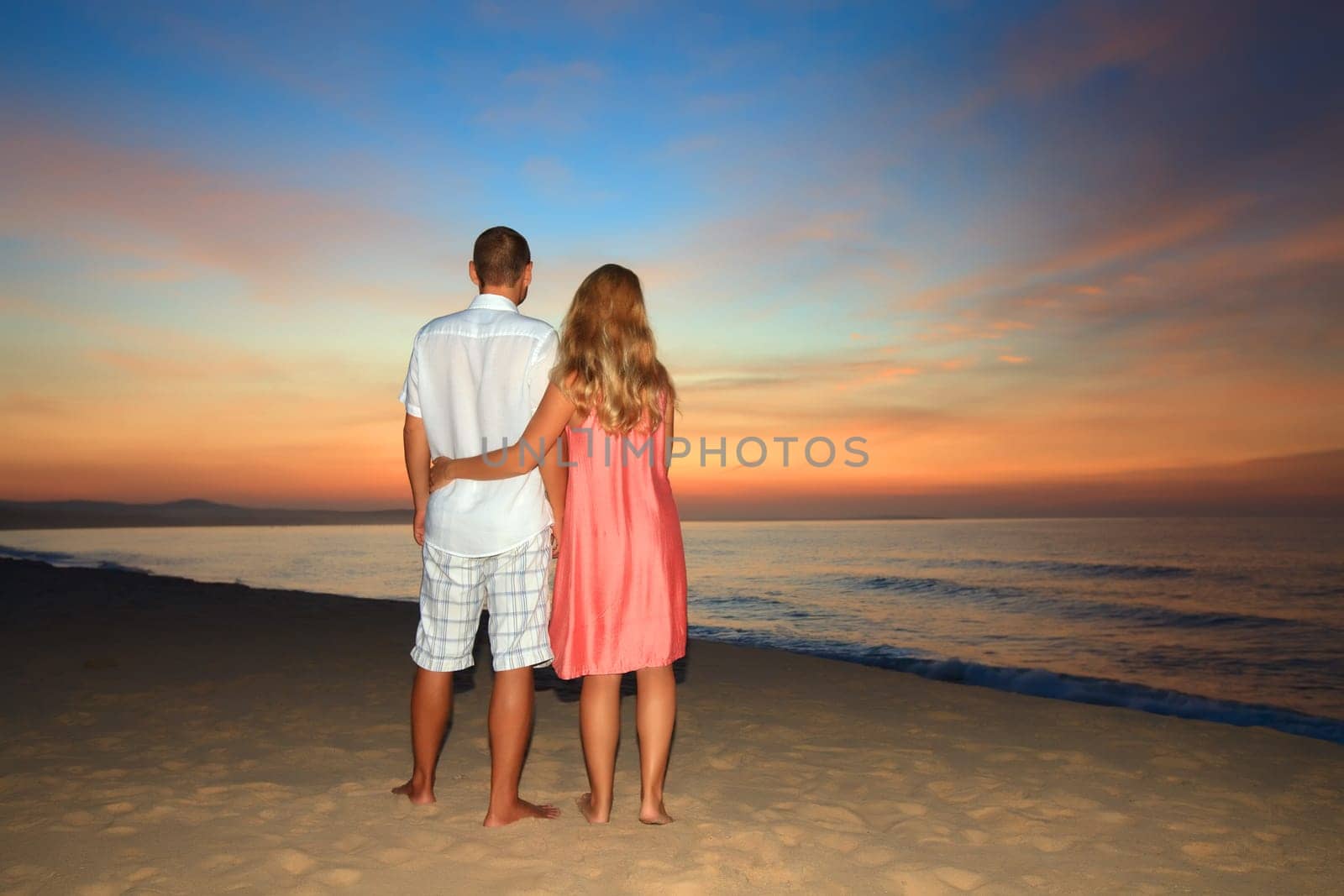 Couple on the beach at sunrise time.