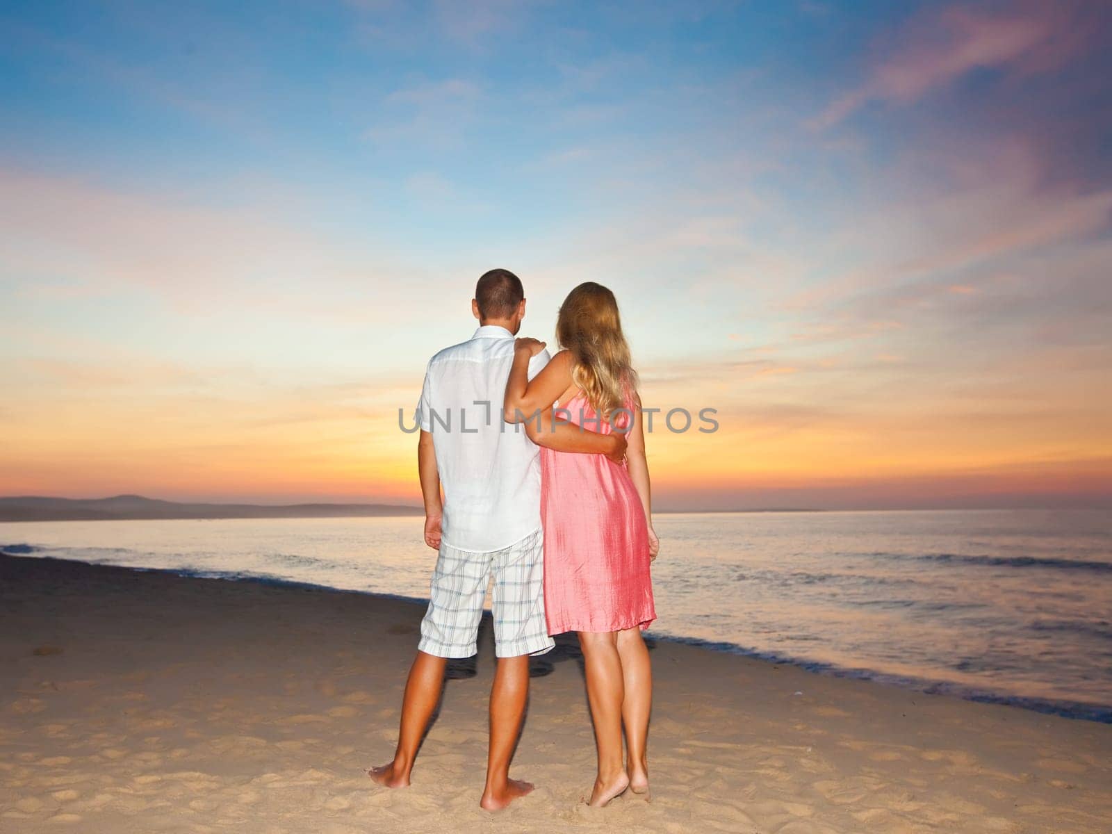 Couple on the beach at sunrise time.