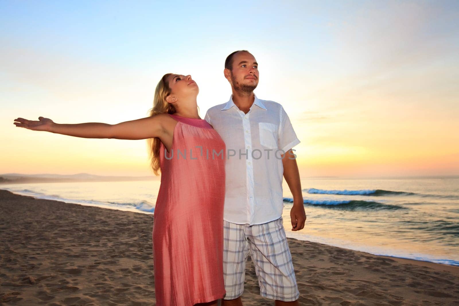 Couple on the beach at sunrise time.