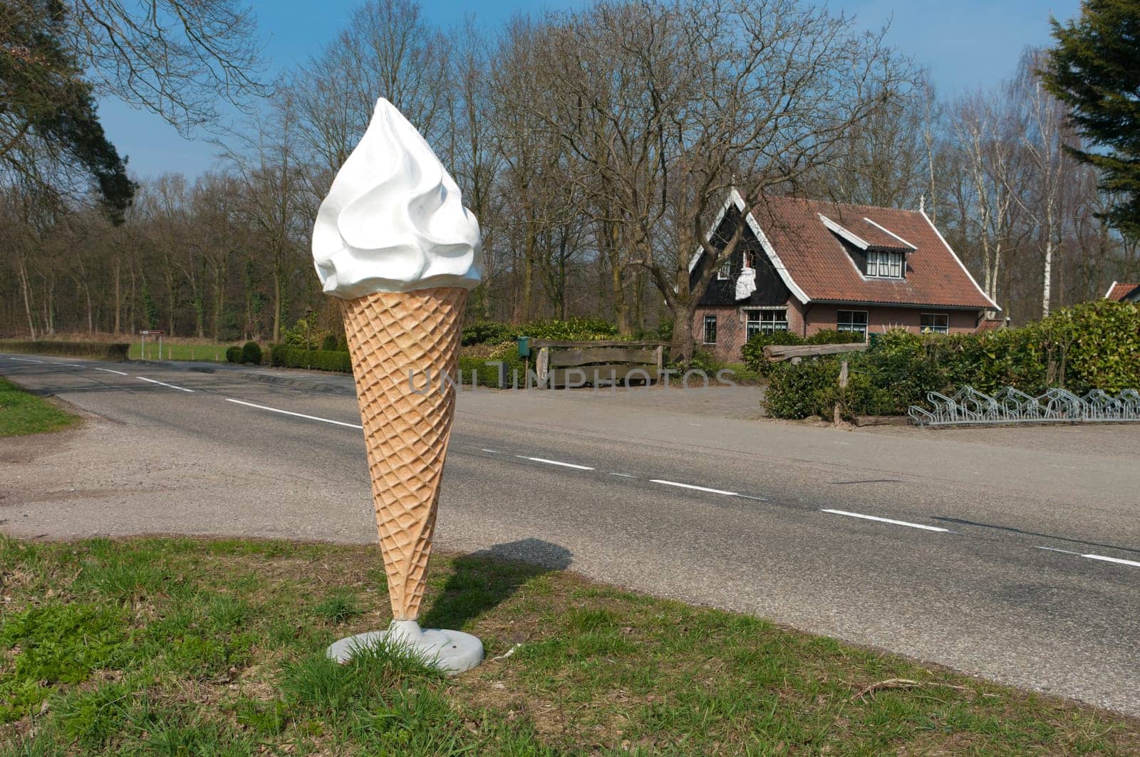 large ice cream cone statue at the side of the road to attract people