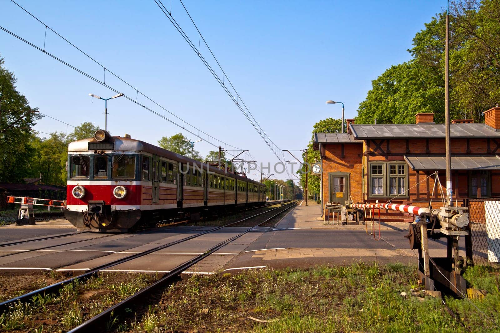 Passenger train passing the railroad crossing with the road