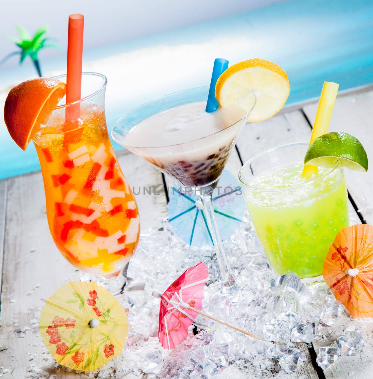 Three different colourful tropical fruit bubble tea sorts served chilled on a bed of crushed ice as a welcome refreshment at a beachfront resort