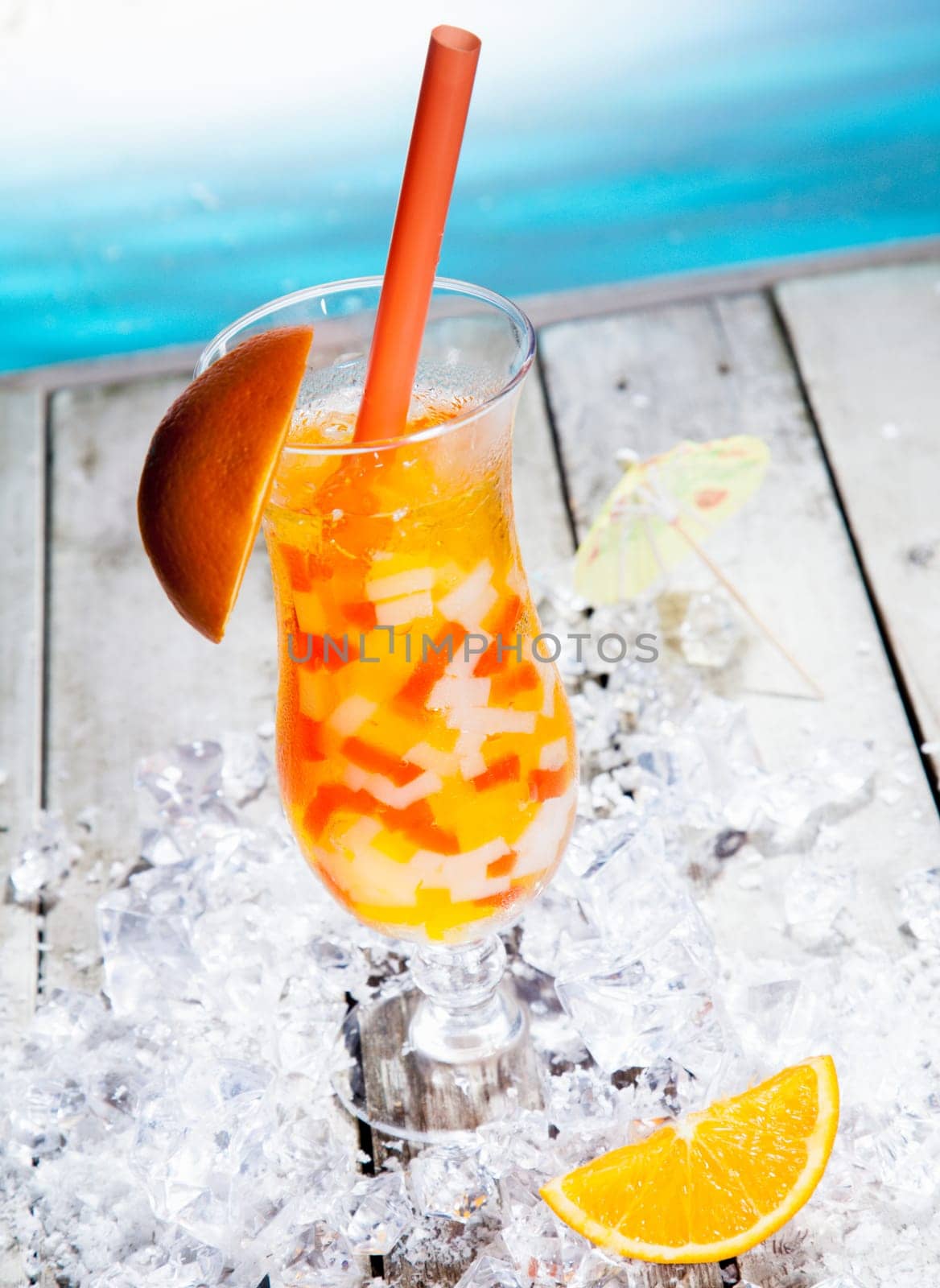 Fruity Boba Cocktail Tea standing in front of a beach background with beautiful paper umbrellas.