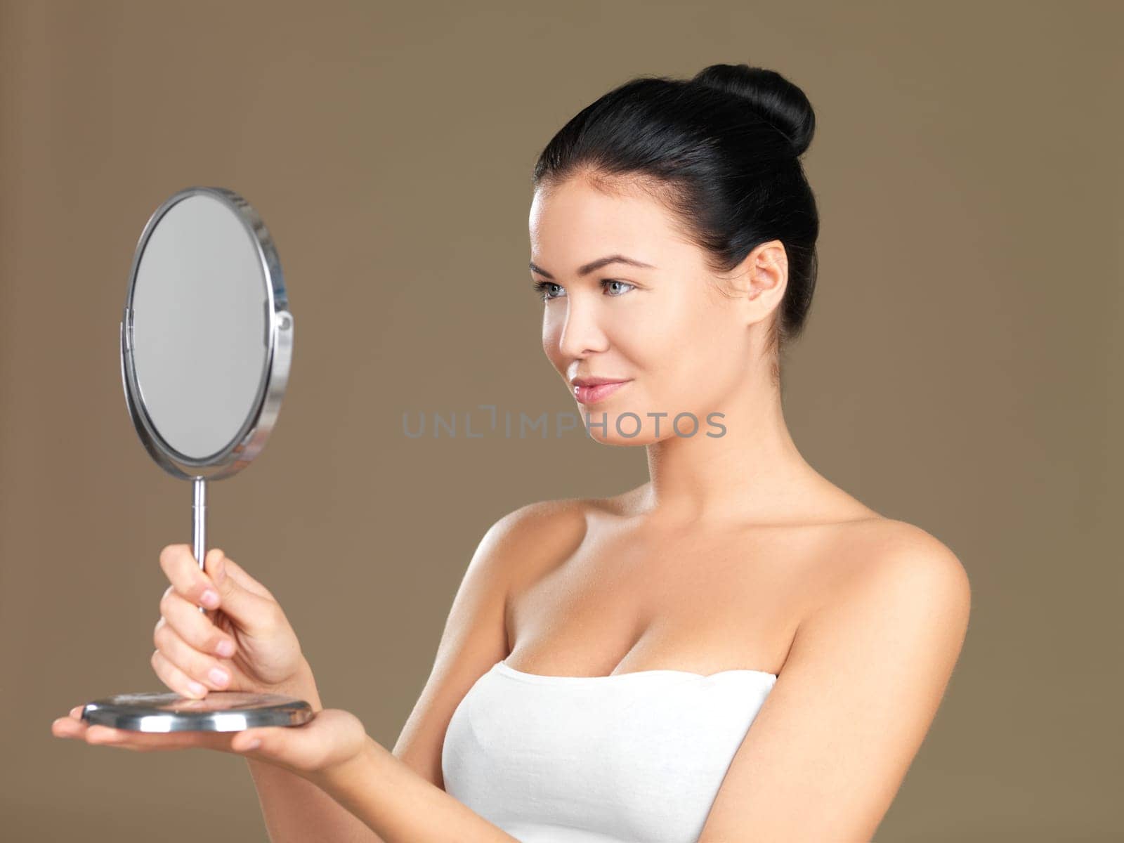 Portrait of beautiful woman, she is looking at the mirror