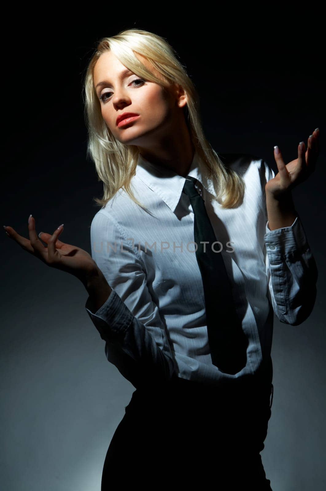 Blond model, business woman pose on black background