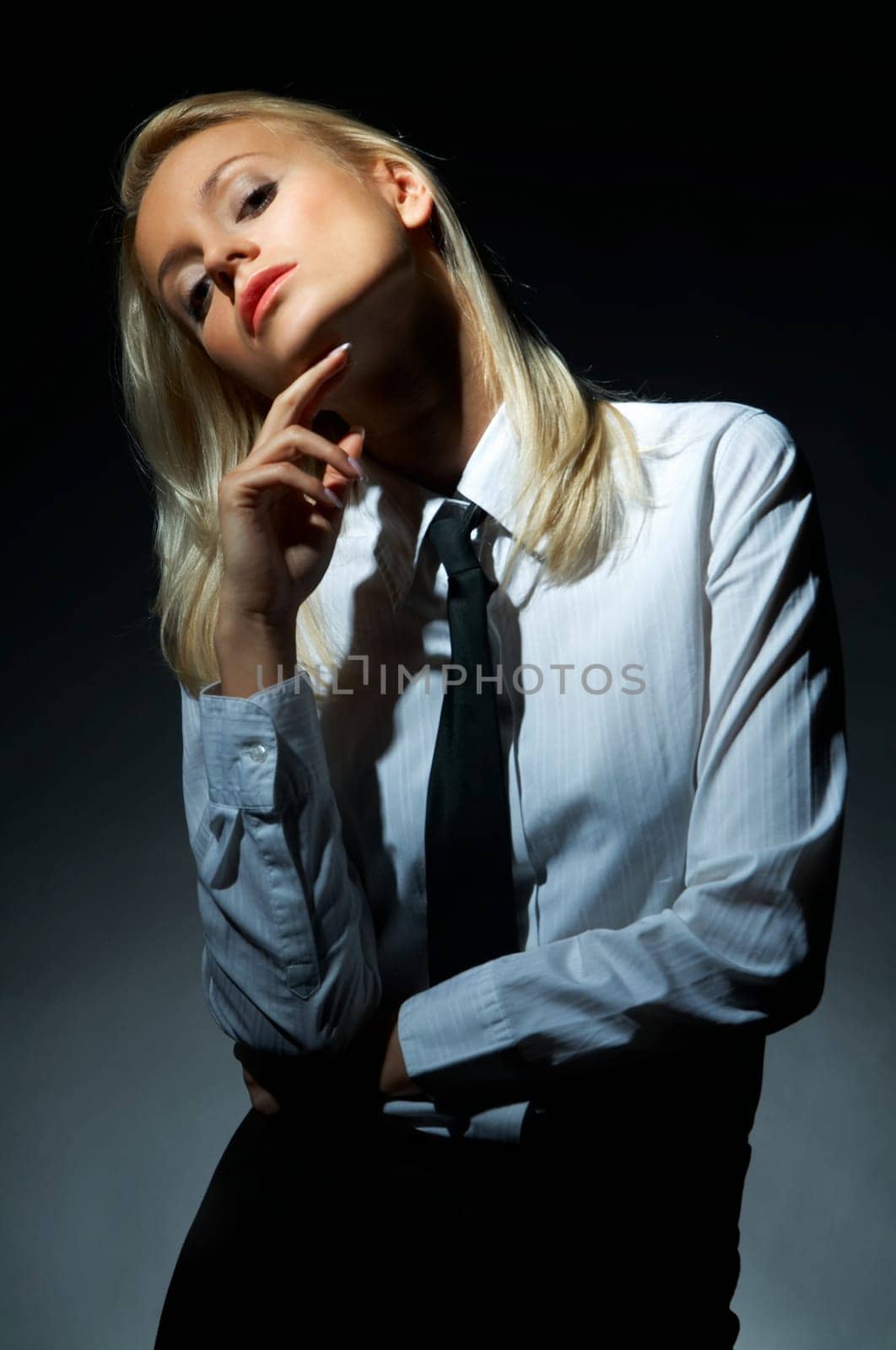 Blond model, business woman pose on black background