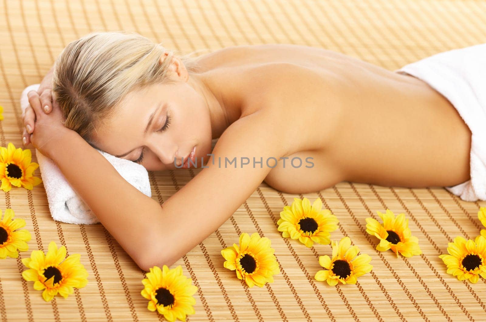 Portrait of Beautiful woman laying on bamboo mat around yellow flowers
