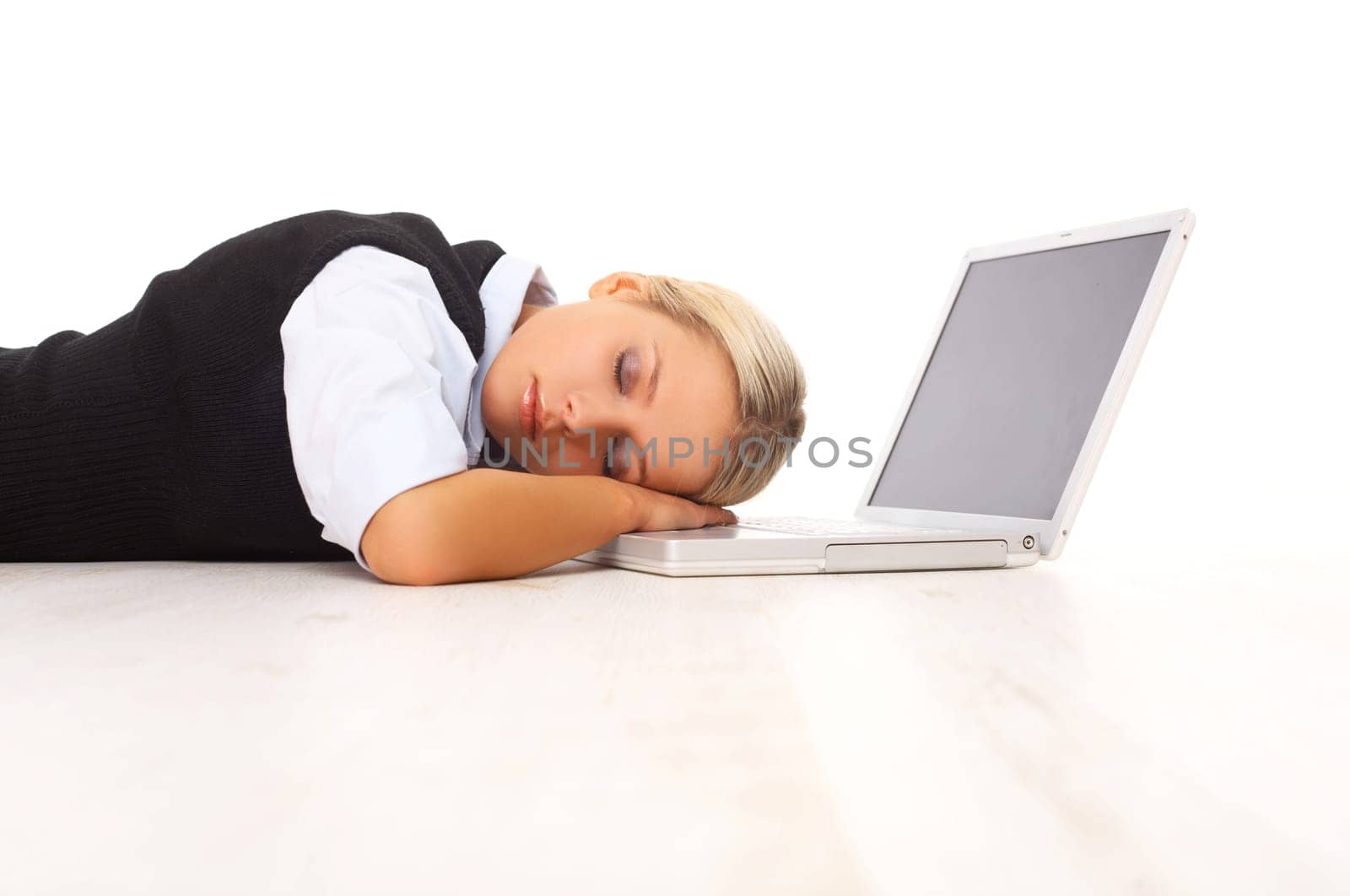 Businesswoman working on her laptop while lying down on the floor