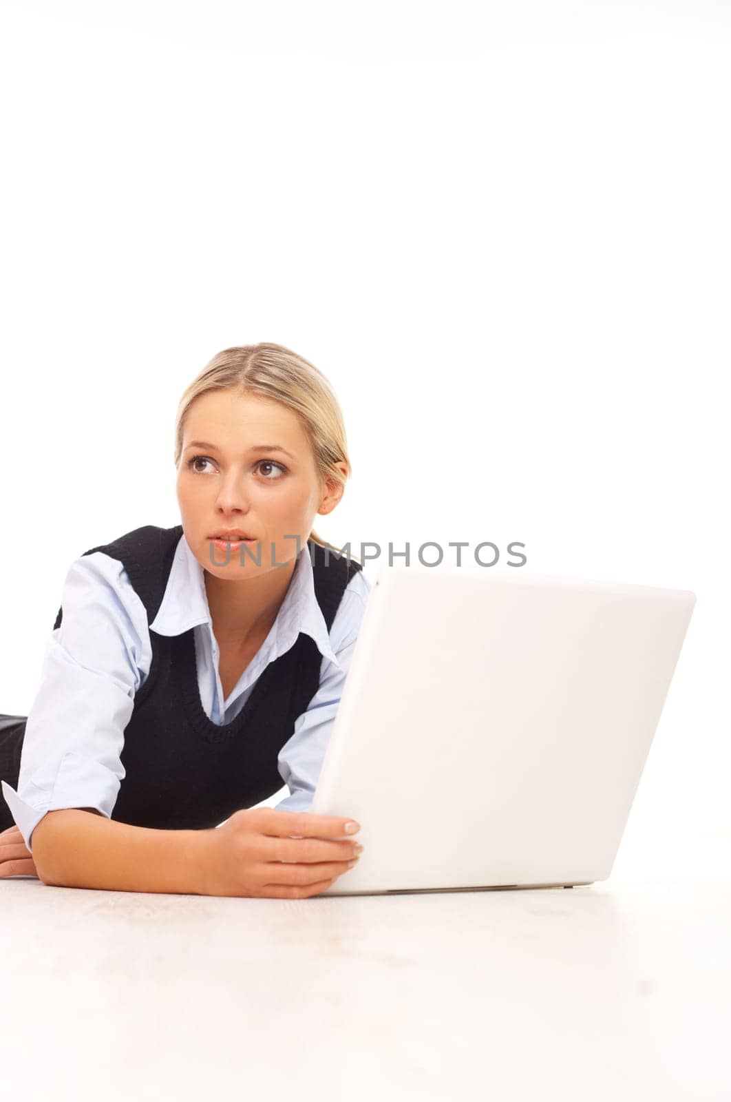 Businesswoman working on her laptop while lying down on the floor