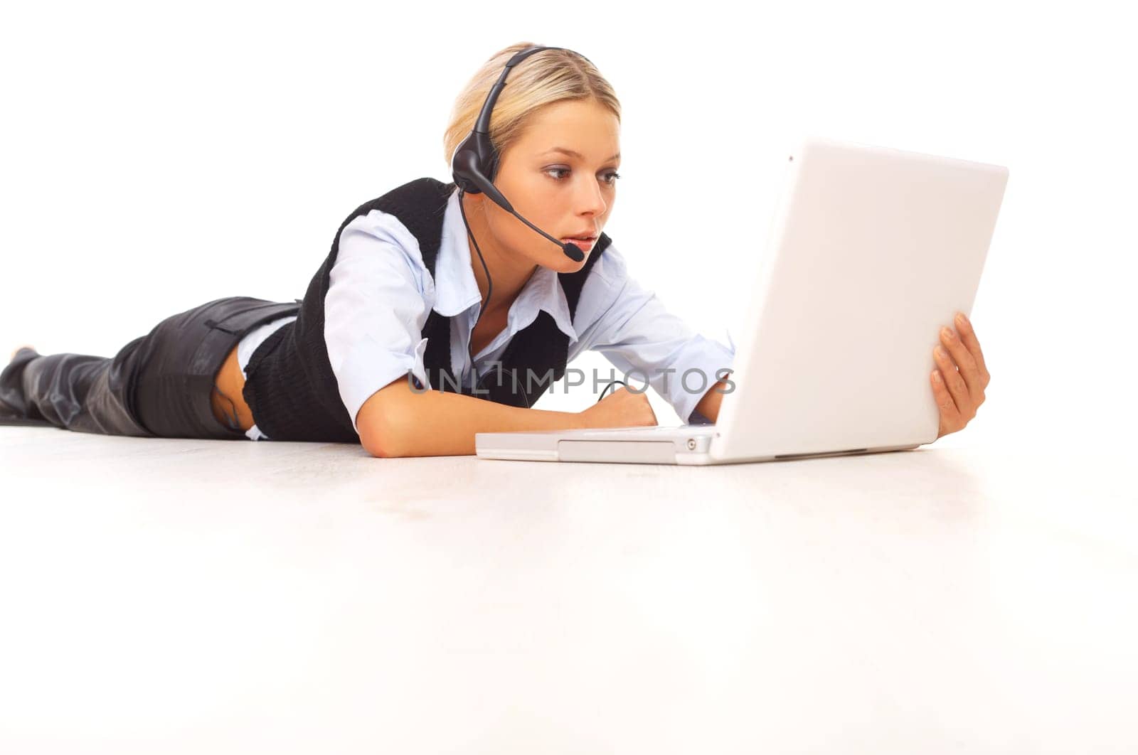 Businesswoman working on her laptop while lying down on the floor
