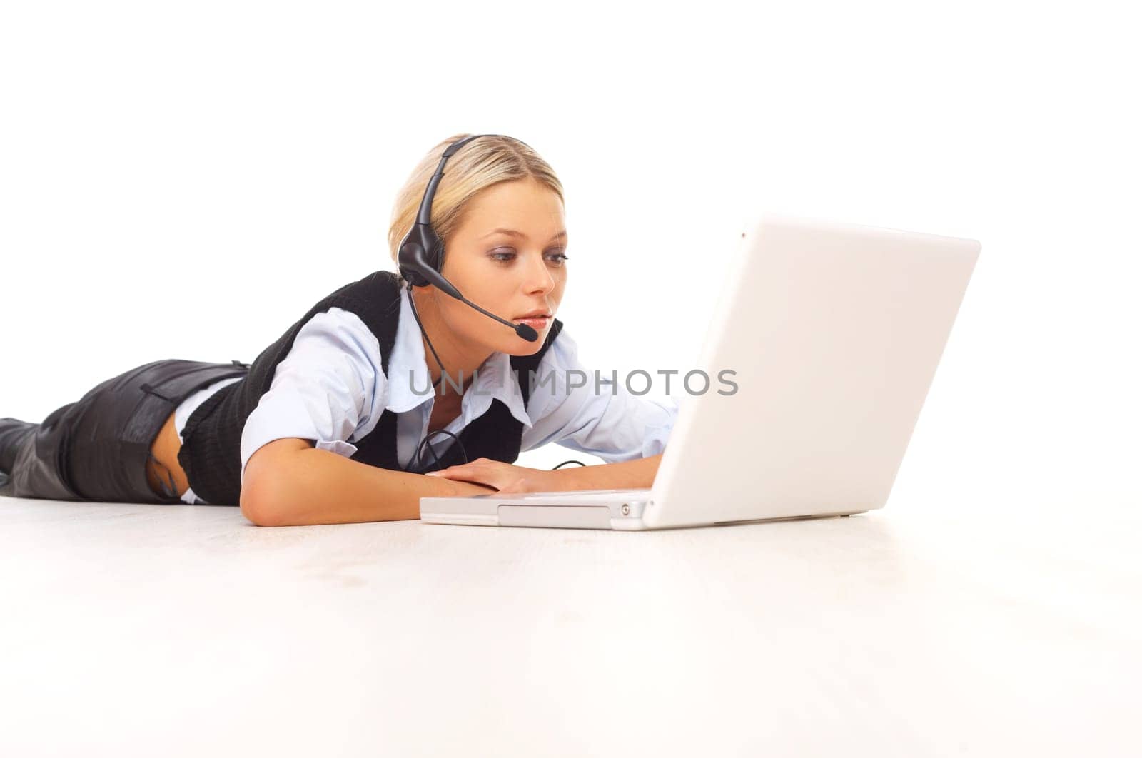 Businesswoman working on her laptop while lying down on the floor