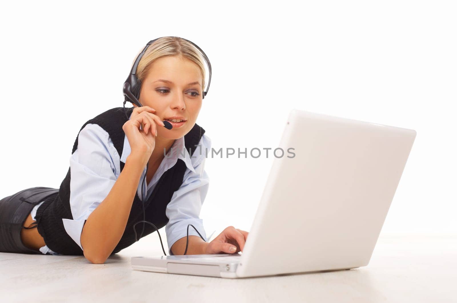 Businesswoman working on her laptop while lying down on the floor
