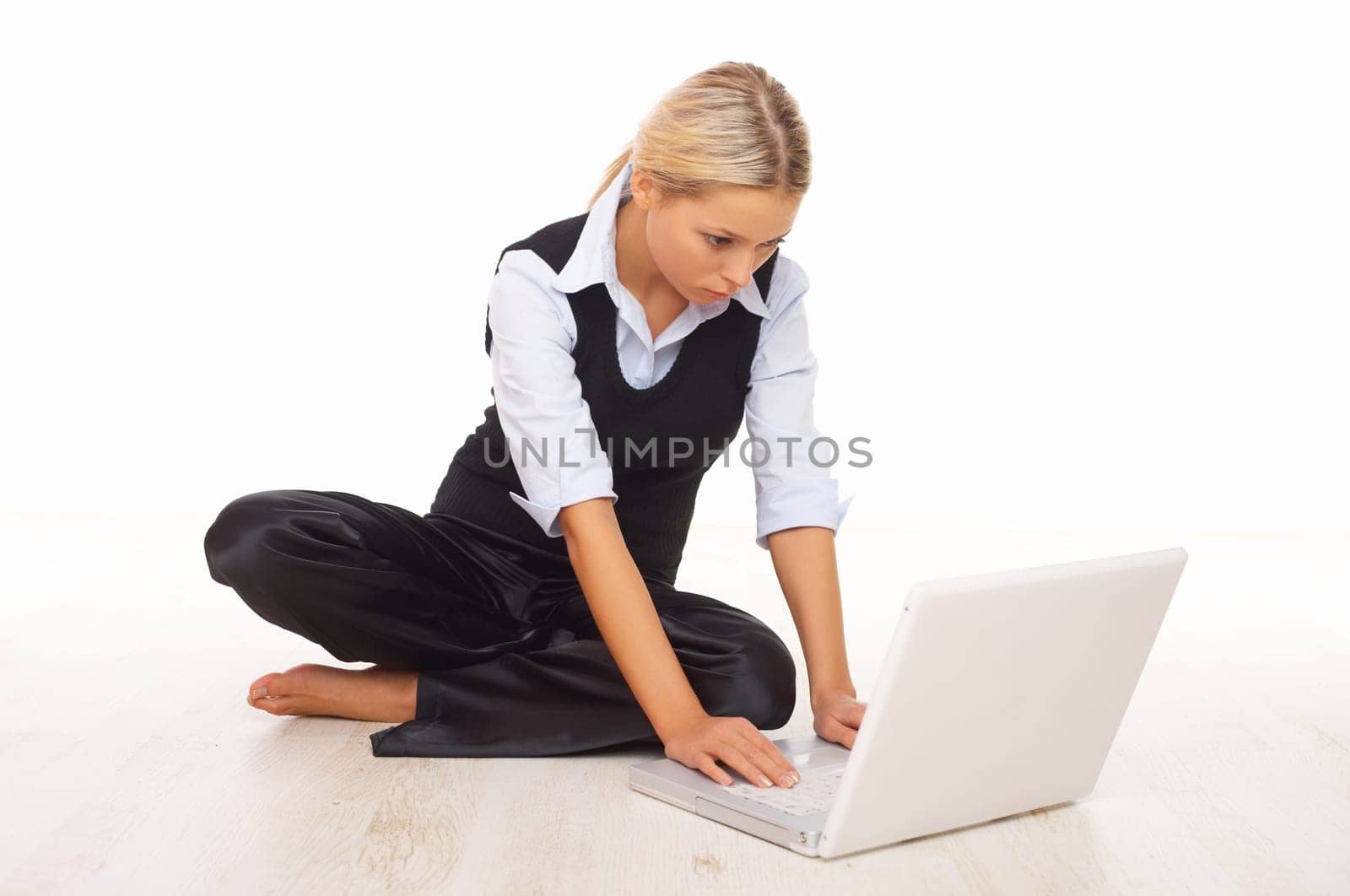 Businesswoman working on her laptop while sitting on the floor