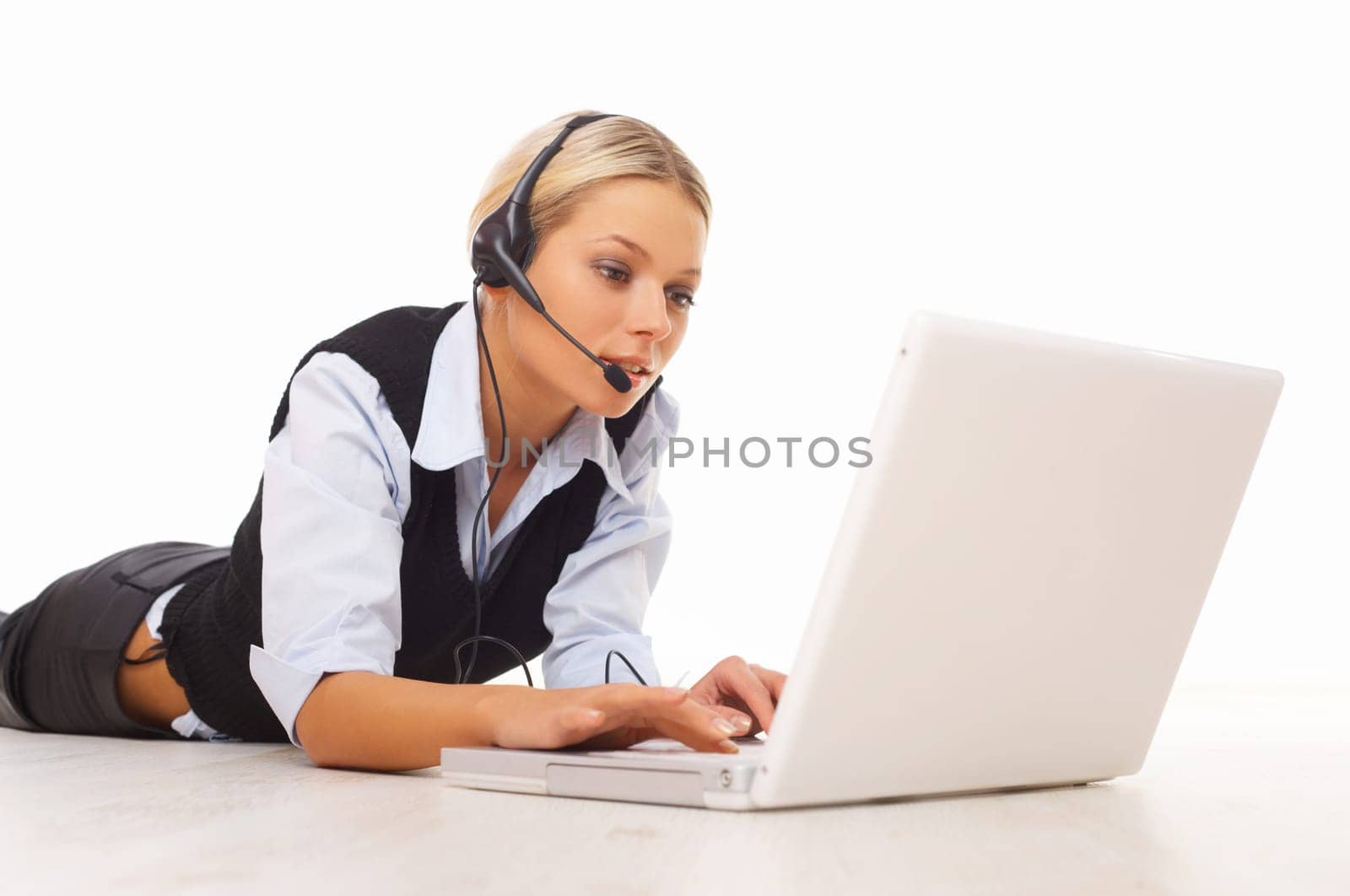 Businesswoman working on her laptop while lying down on the floor