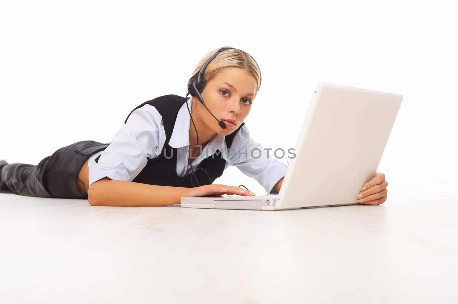 Businesswoman working on her laptop while lying down on the floor