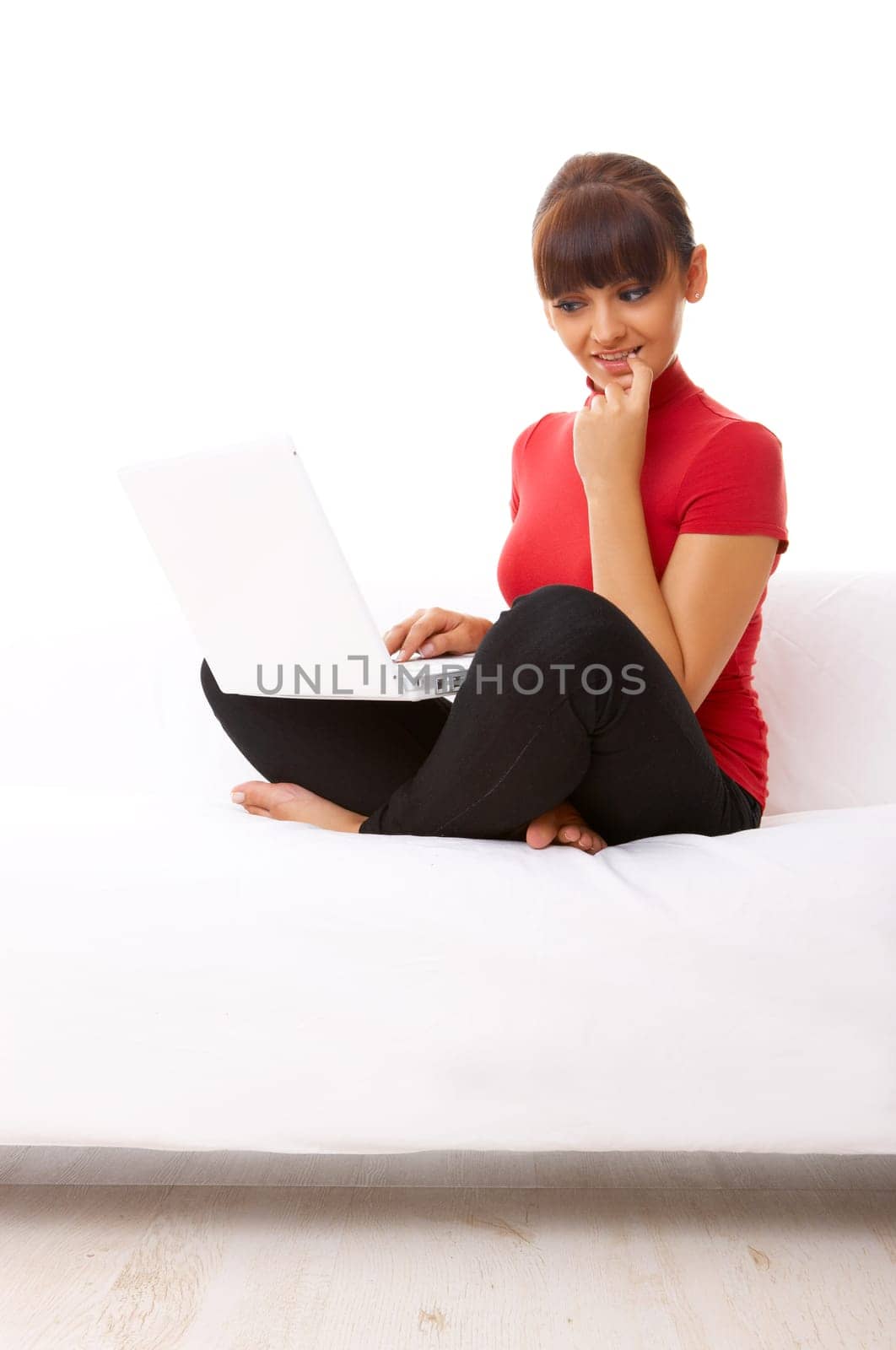 Young pretty women on white couch relaxing and using laptop computer