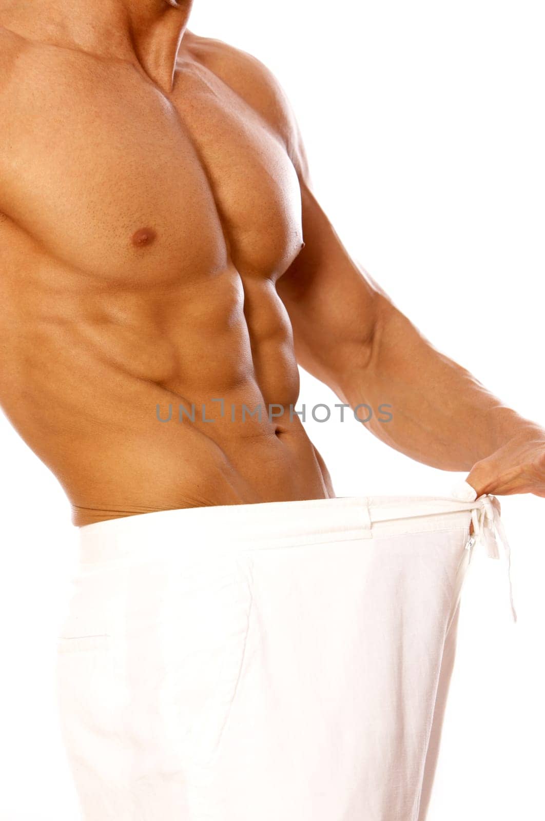 Muscular and tanned male in old pants after weight loss