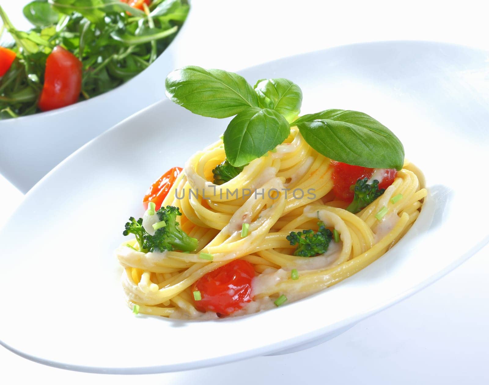 Spaghetti with Broccoli and Tomato with a cream cheese Sauce and Basil. Rucola Tomato and corn Salad in the Background.