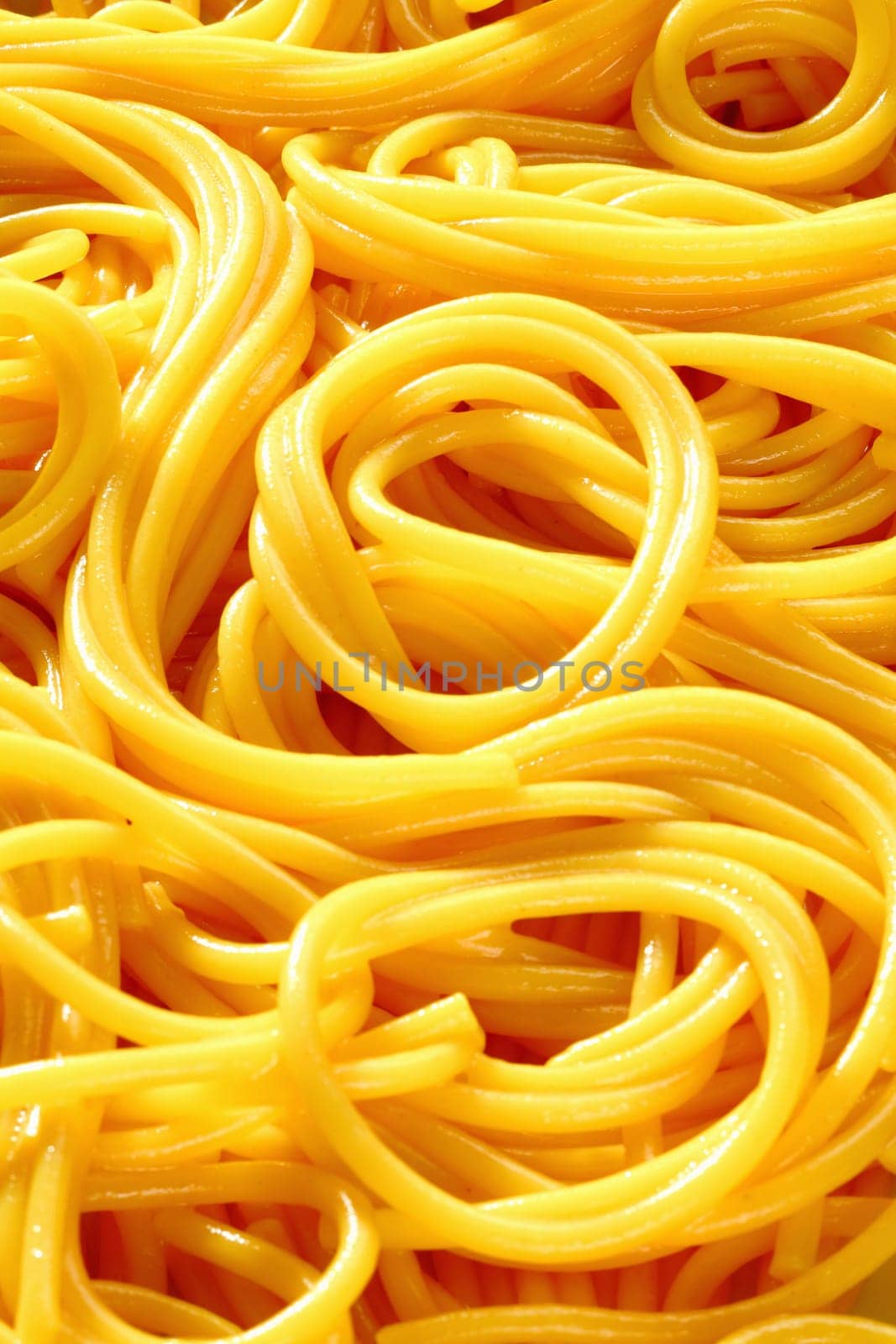 Closeup of freshly boiled spaghetti coiled in random patterns for an interesting background.