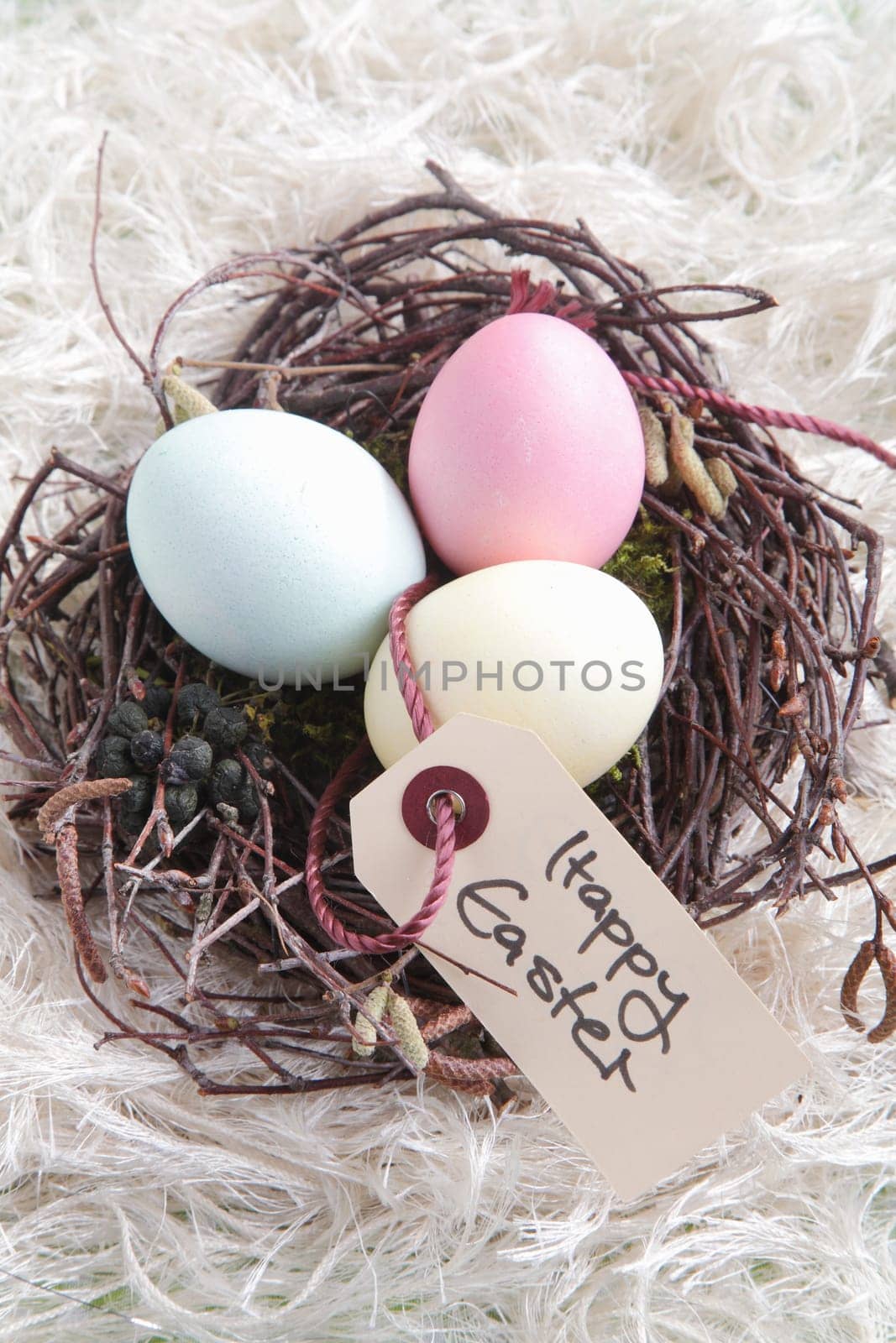 Three Easter Eggs in a nest with a handwritten Happy Easter sign