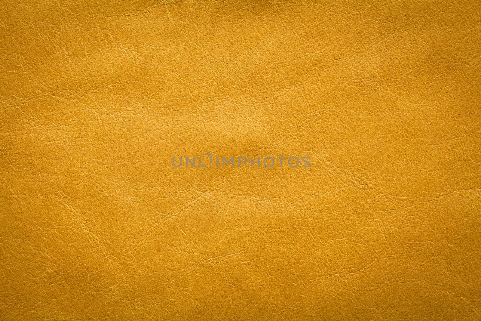 Abstract background of textured leather with creases and a slightly puckered surface.