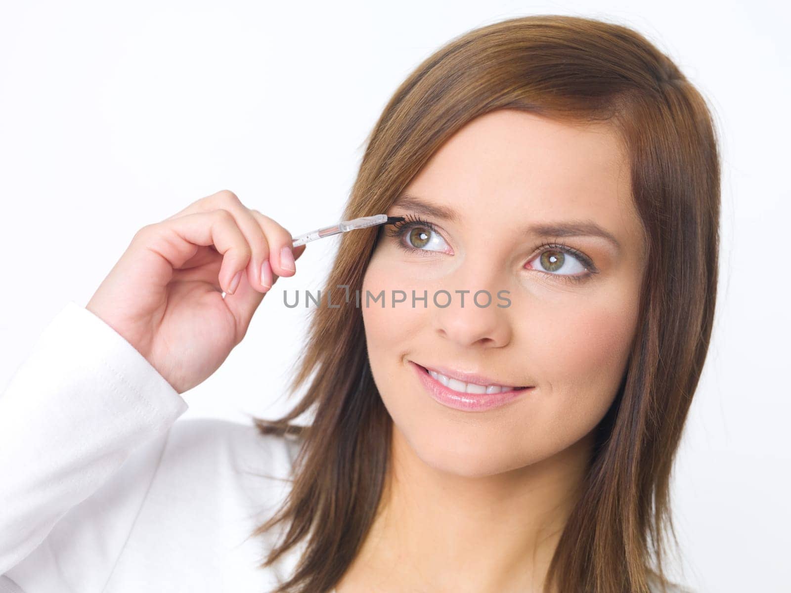 Portrait of beautiful young woman is doing her makeup