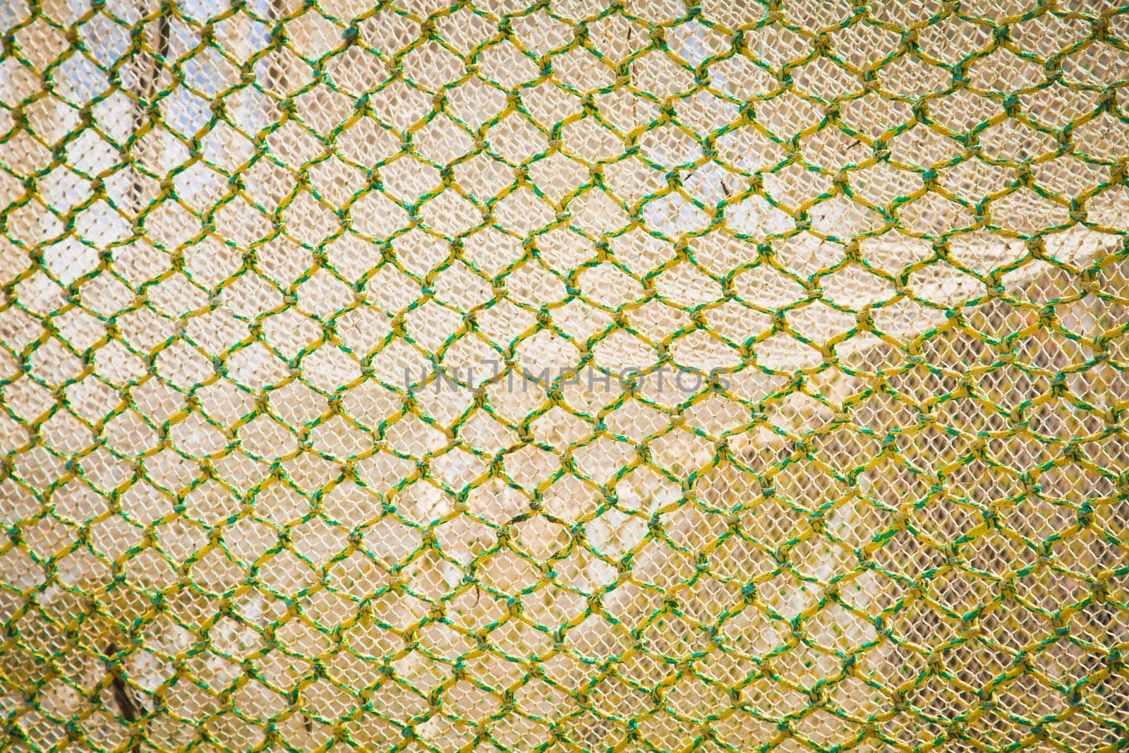 Abstract background of openframe knotted yellow green netting used by trawlers as a trawlnet when deep sea fishing