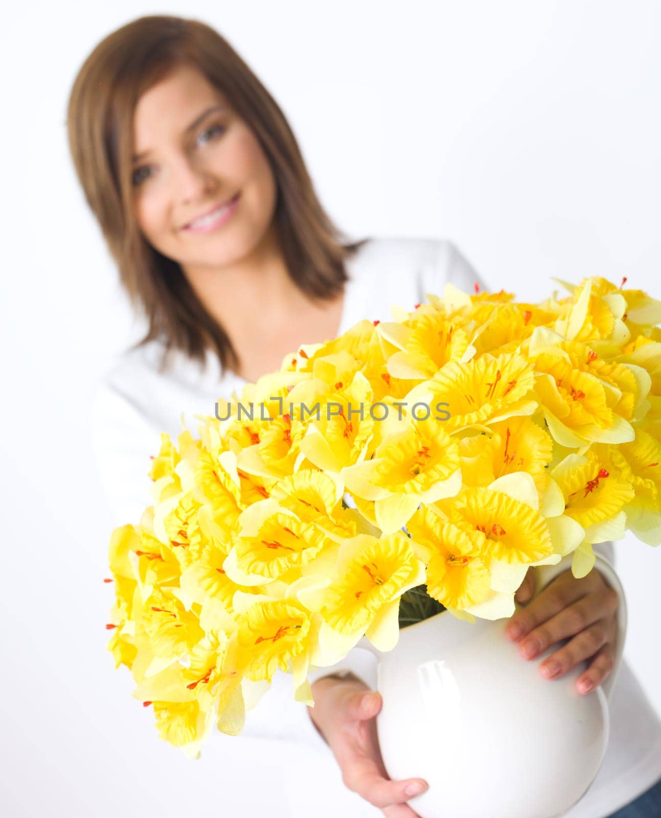 Portrait of beautiful young woman holding vase of flowers