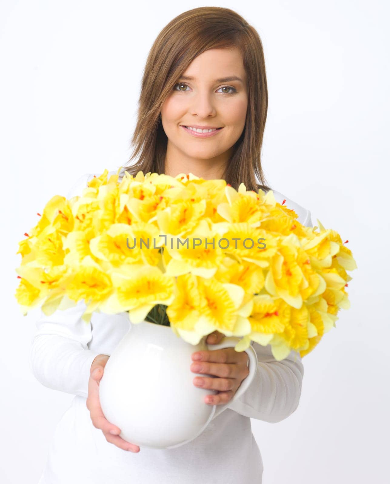 Portrait of beautiful young woman holding vase of flowers