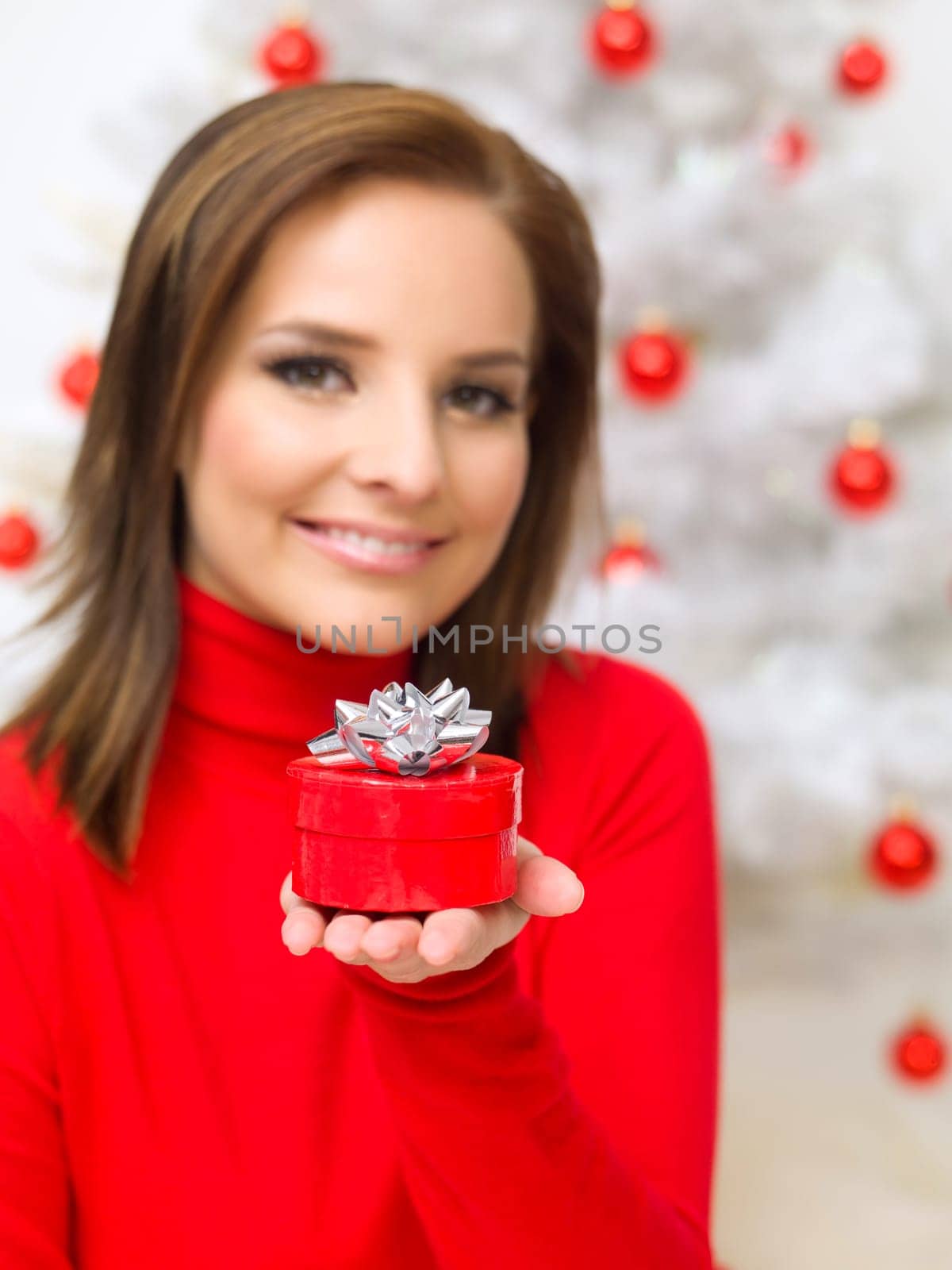 Beautiful woman next to christmas tree wearing red sweater