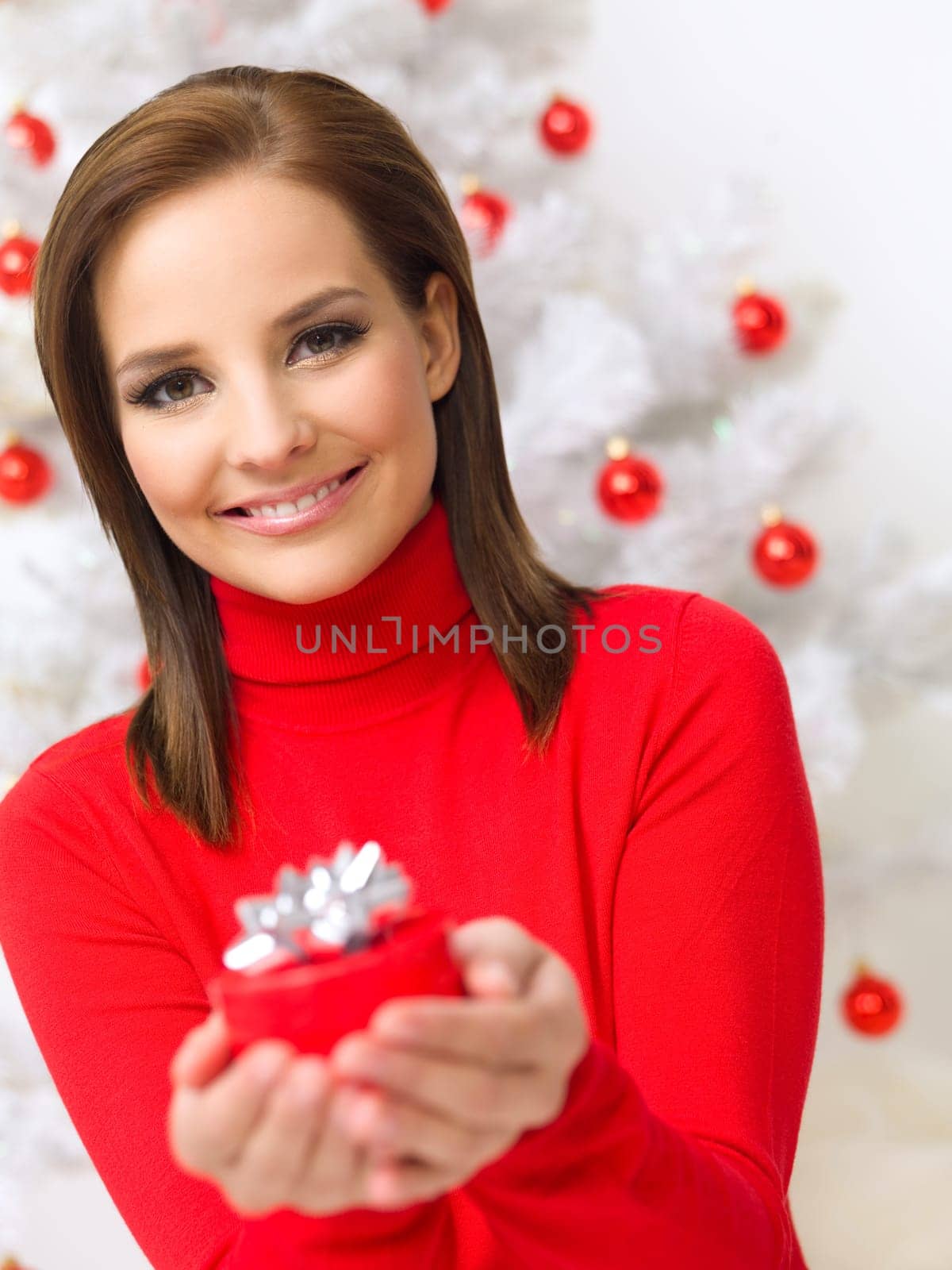 Beautiful woman next to christmas tree wearing red sweater