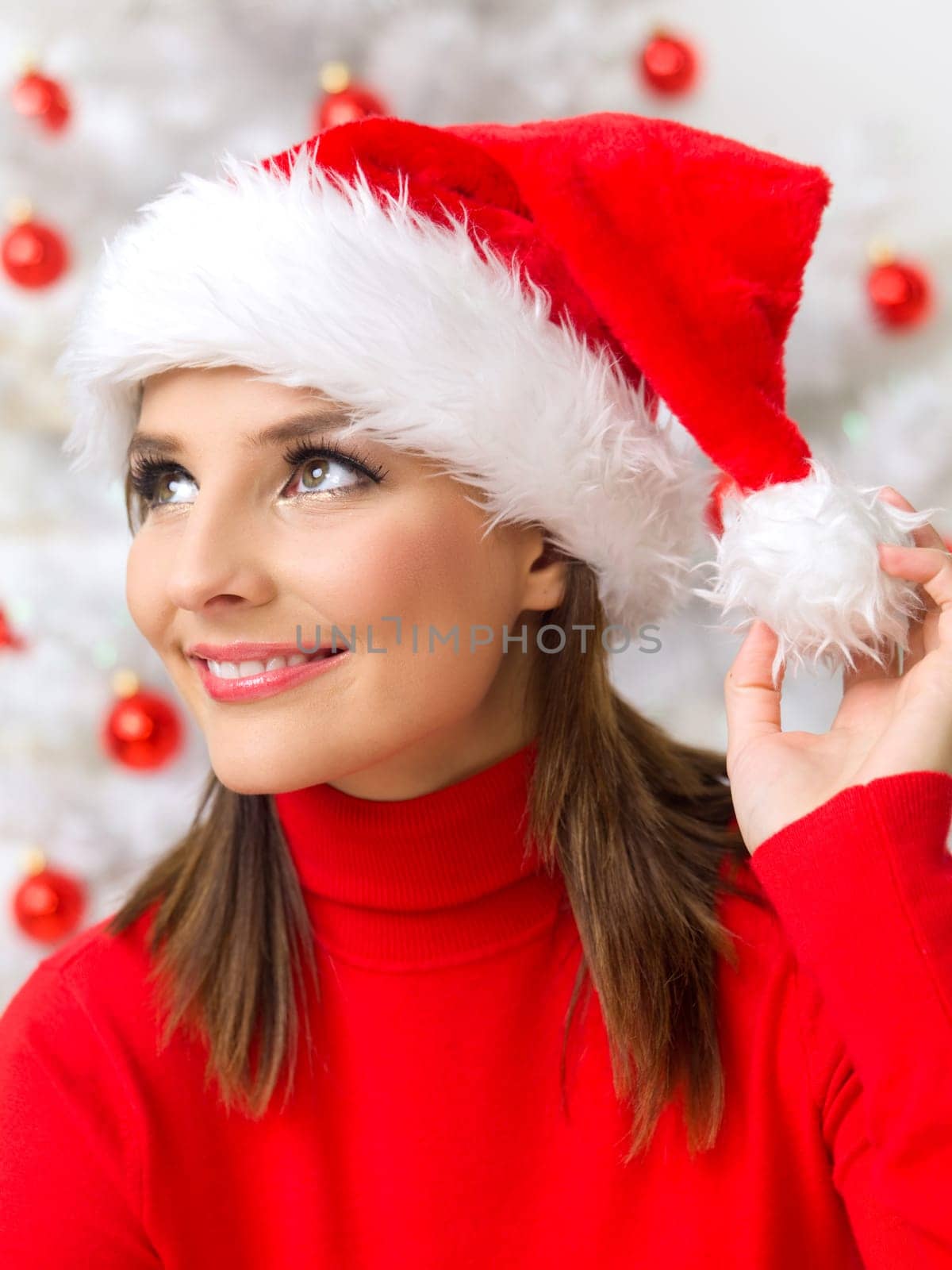 Beautiful woman next to christmas tree wearing red sweater