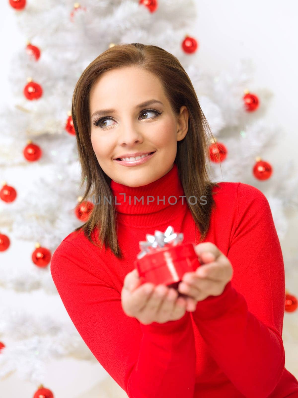 Beautiful woman next to christmas tree wearing red sweater