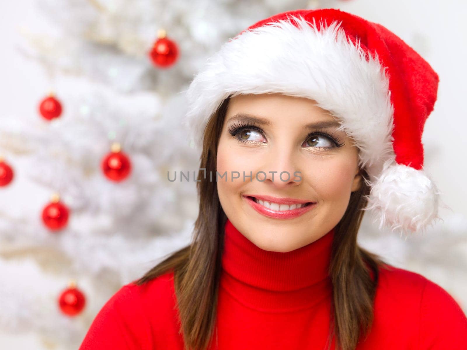 Beautiful woman next to christmas tree wearing red sweater