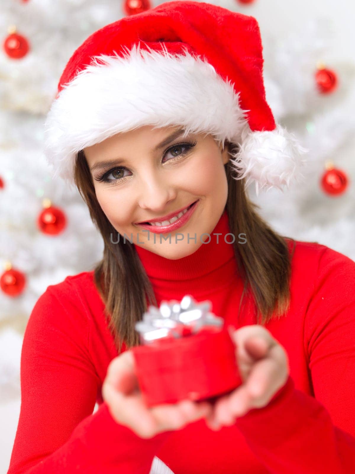 Beautiful woman next to christmas tree wearing red sweater