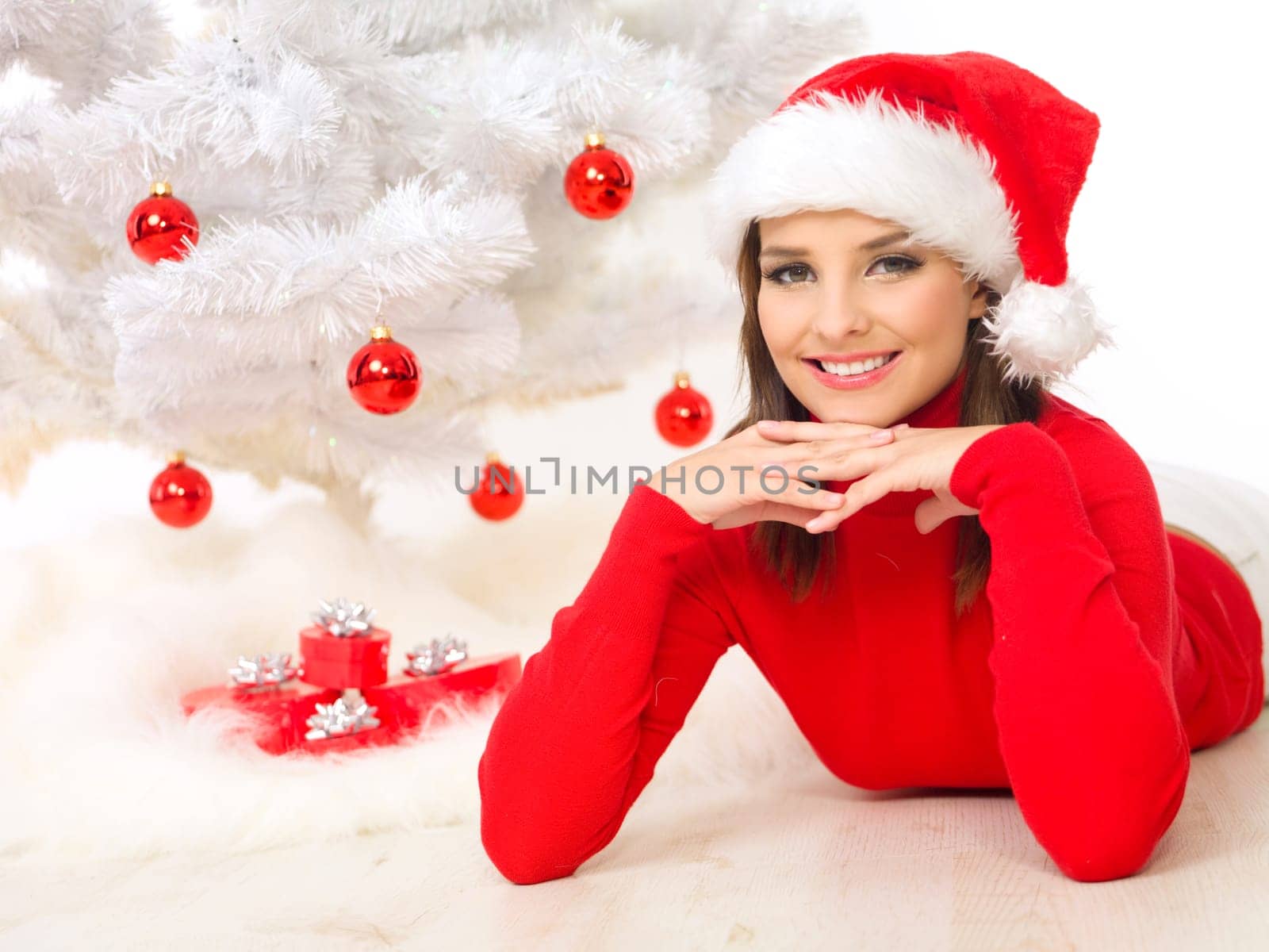 Beautiful woman next to christmas tree wearing red sweater