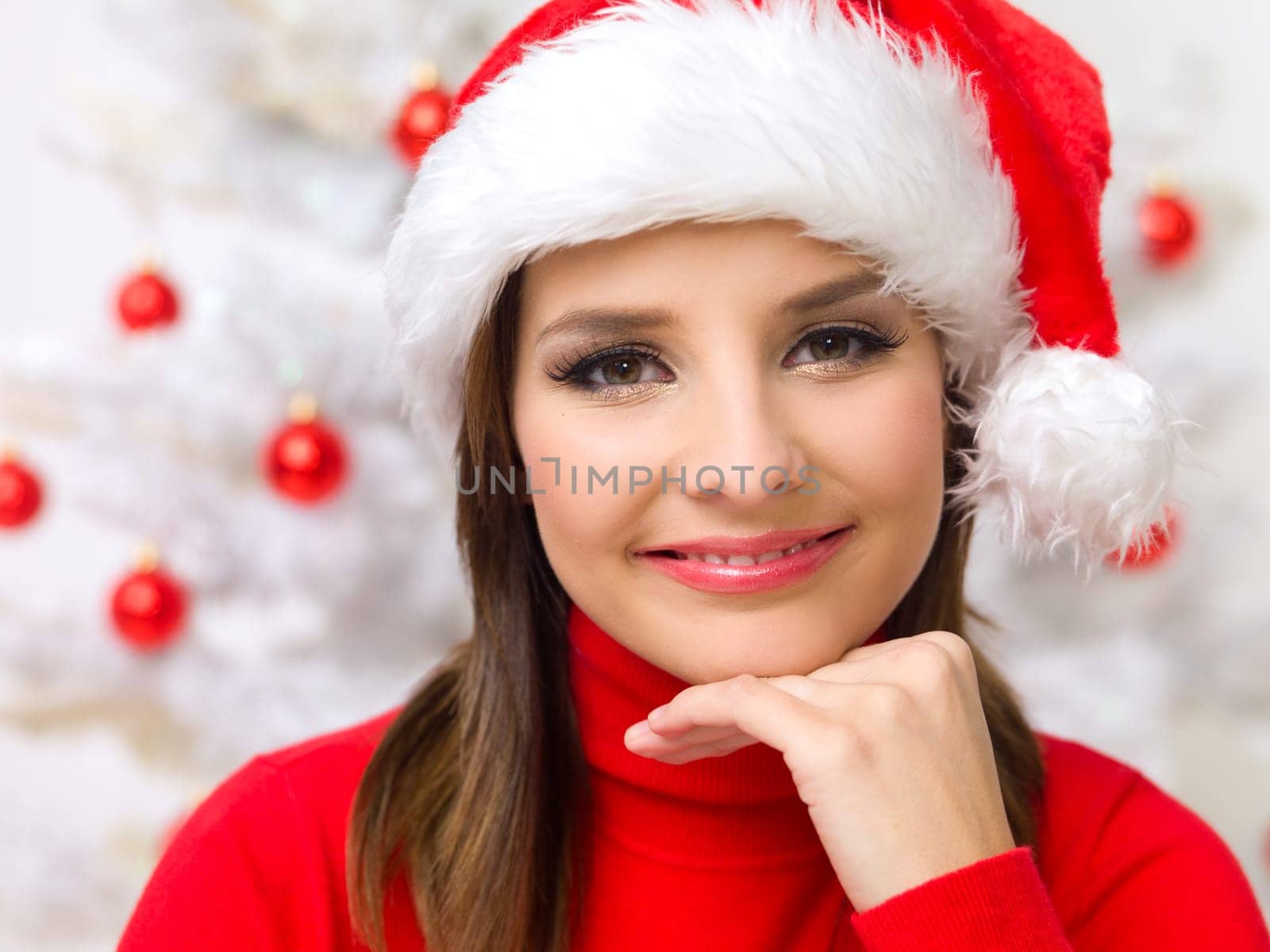 Beautiful woman next to christmas tree wearing red sweater