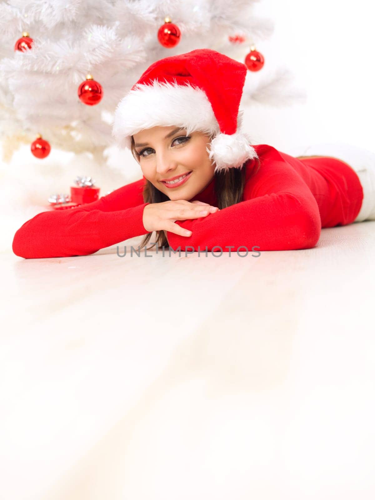 Beautiful woman next to christmas tree wearing red sweater