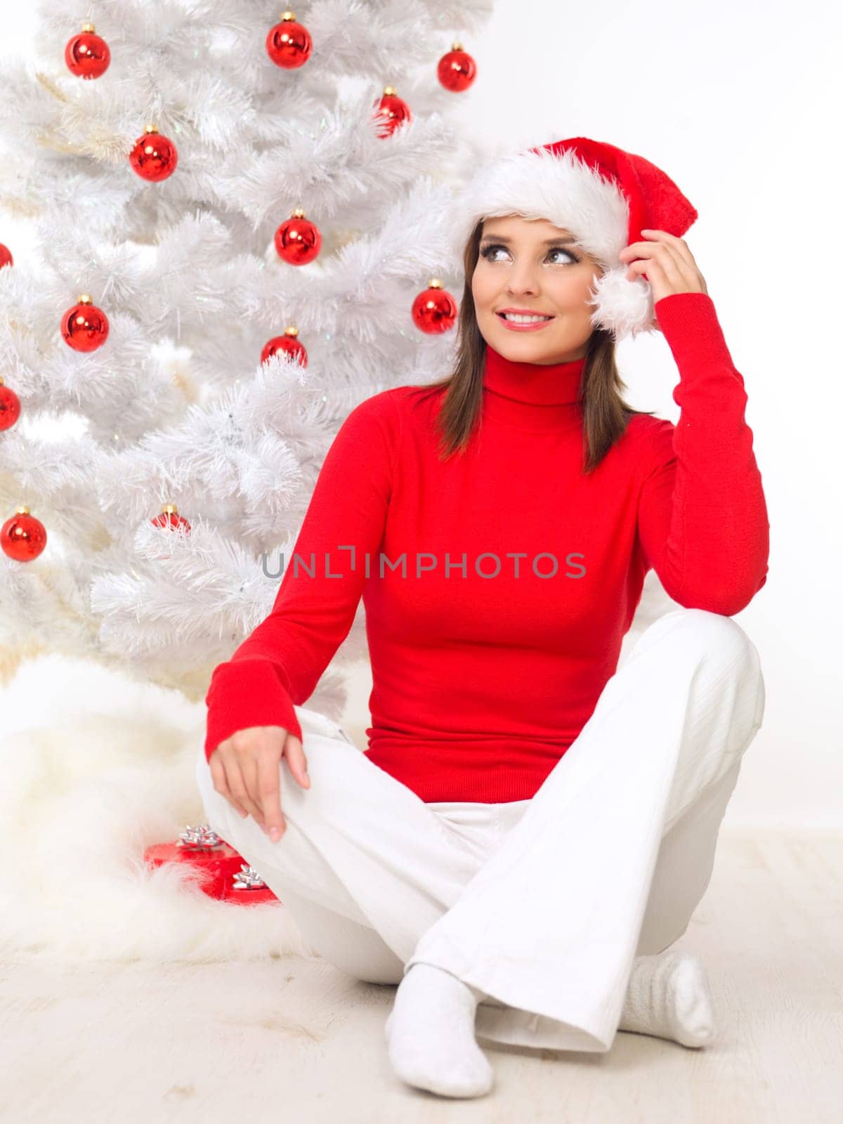 Beautiful woman next to christmas tree wearing red sweater