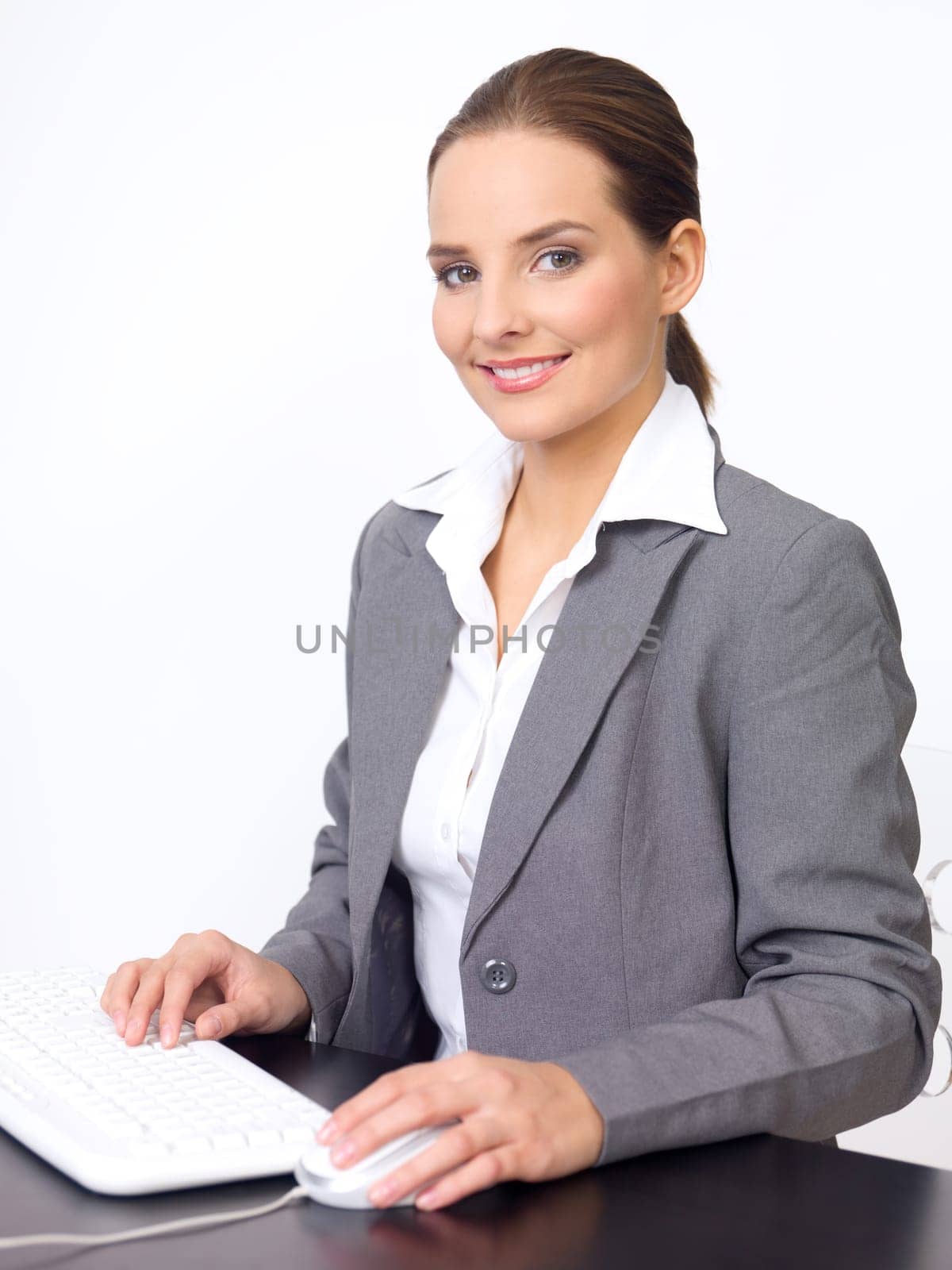 Portrait of beautiful and young business woman working on computer