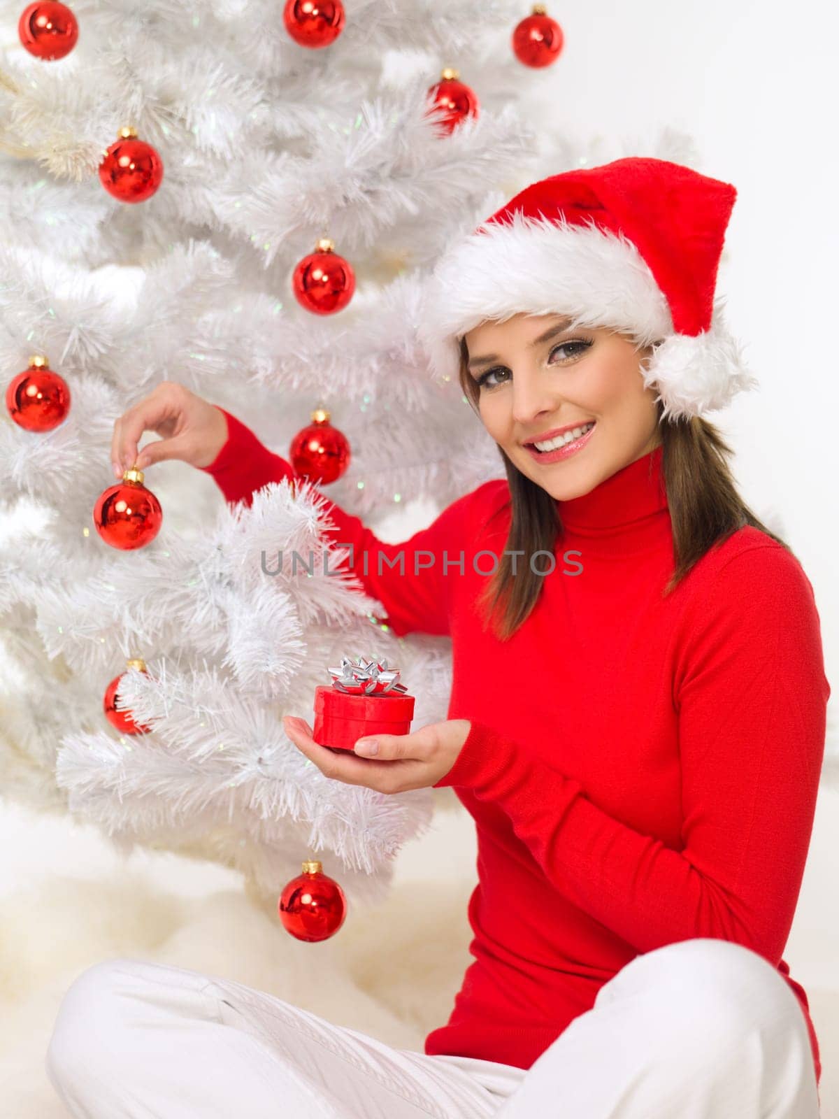 Beautiful woman next to christmas tree wearing red sweater
