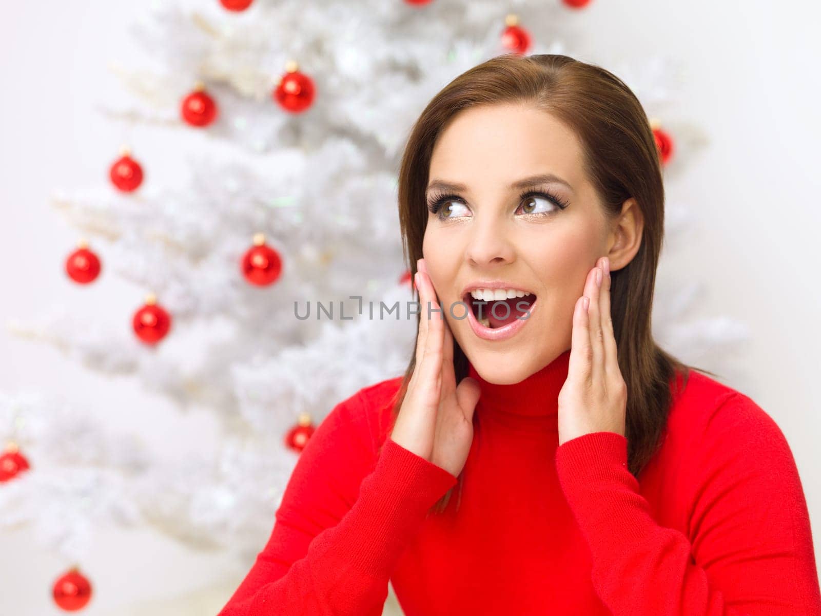 Beautiful woman next to christmas tree wearing red sweater