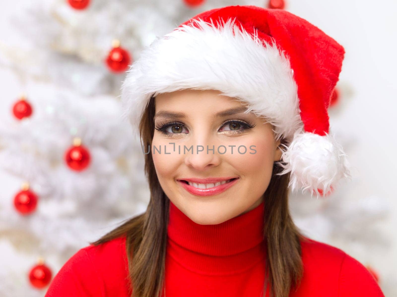 Beautiful woman next to christmas tree wearing red sweater