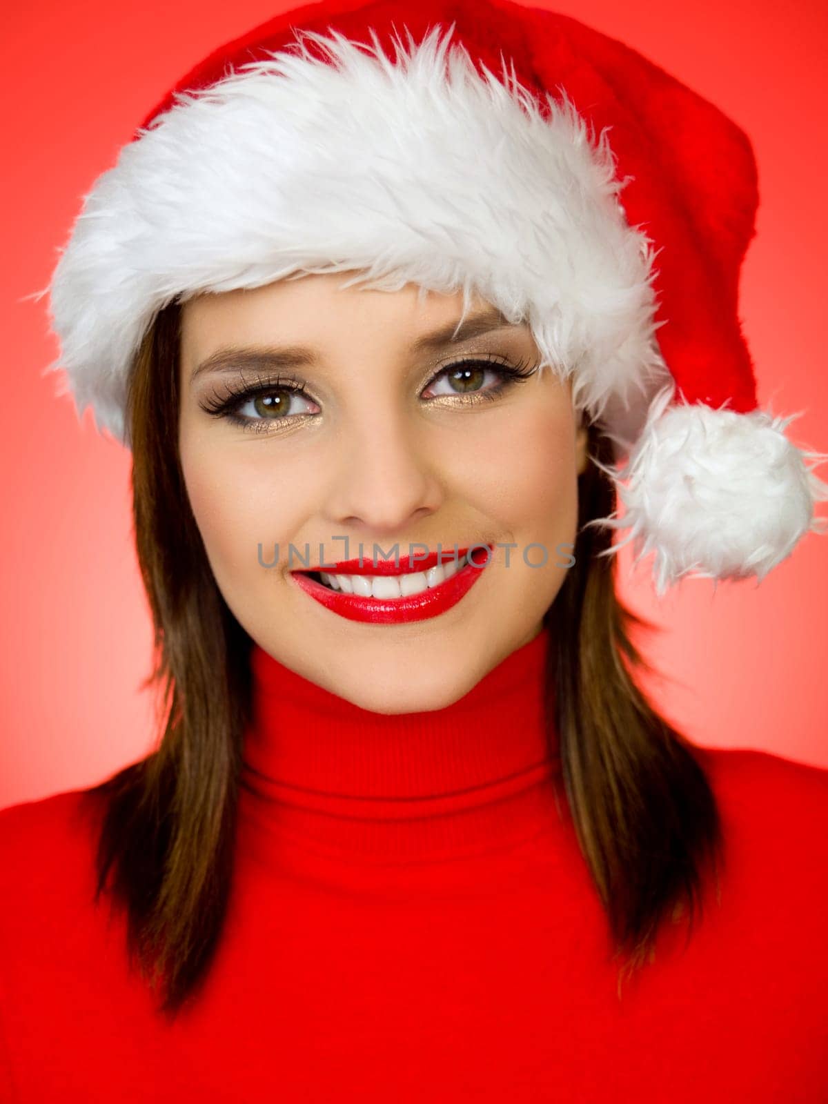 Portrait of beautiful woman wearing santa claus hat on red background