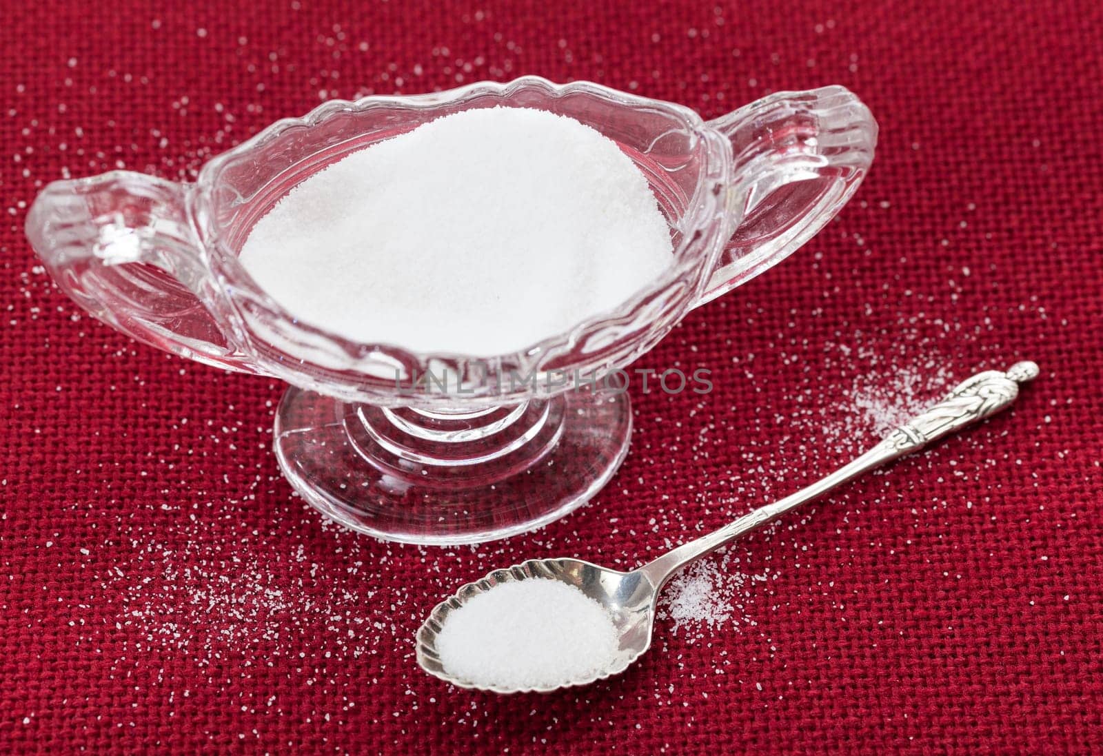 Table salt crystals in cut glass bowl on red tablecloth
