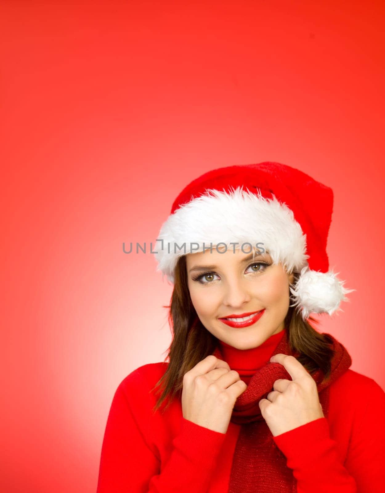 Portrait of beautiful woman wearing santa claus hat on red background