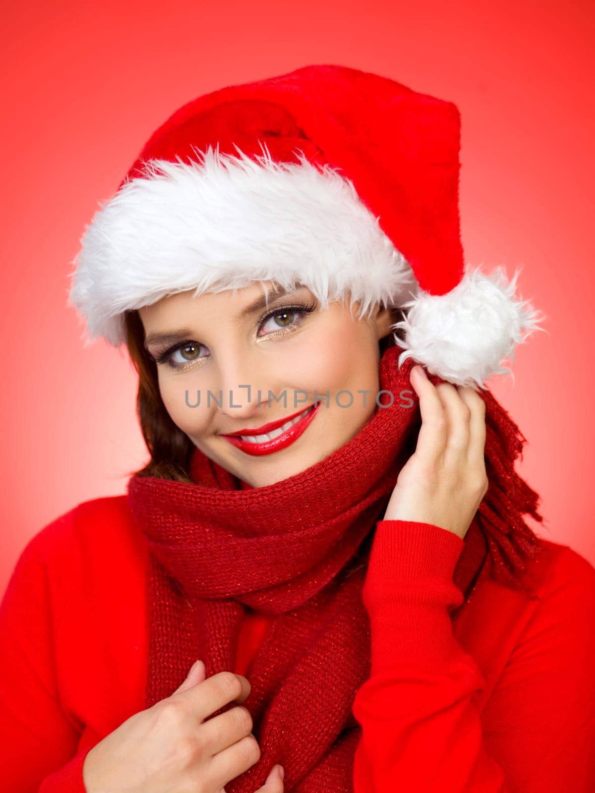 Portrait of beautiful woman wearing santa claus hat on red background