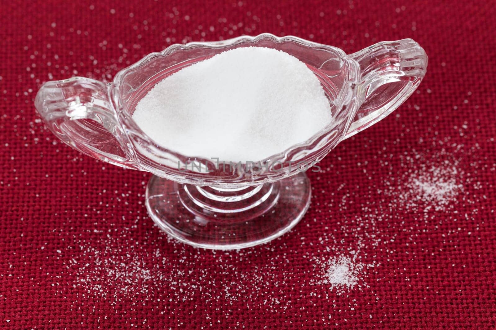 Table salt crystals in cut glass bowl on red tablecloth